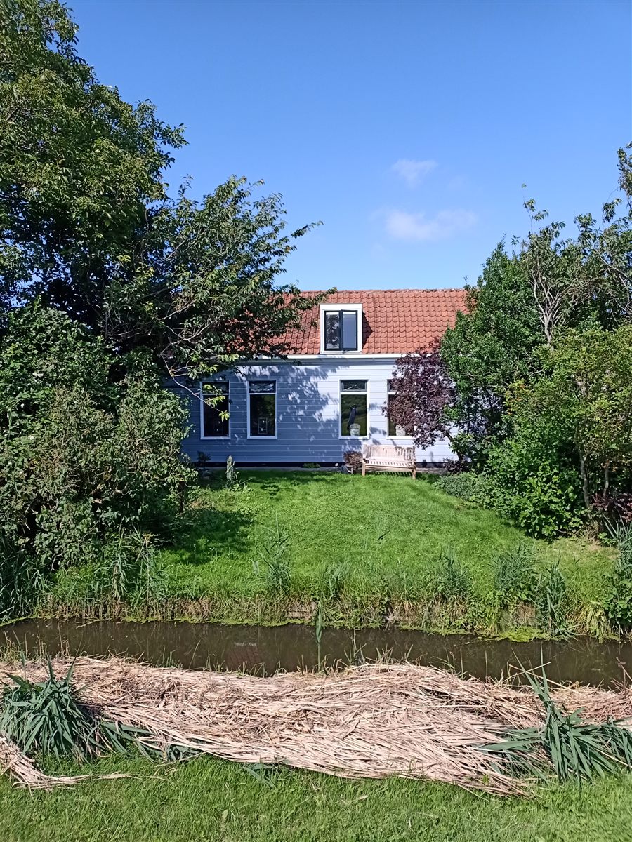 Vrijstaande woning met lichtgrijze geschilderde gevel in landelijke omgeving